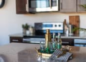 Thumbnail 3 of 42 - a kitchen island with a tray of wine bottles and a napkin on it at The 22 Apartments, St. Louis, MO 63103