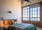 Thumbnail 23 of 42 - a bedroom with a large bed and a large window at The 22 Apartments, St. Louis, MO 63103