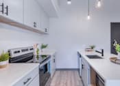 Thumbnail 57 of 61 - A modern kitchen with white cabinets and a black oven.