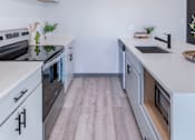 Thumbnail 49 of 61 - A modern kitchen with white cabinets and a wooden floor.