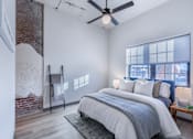 Thumbnail 55 of 61 - A bedroom with a large bed and a ceiling fan.