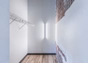 Thumbnail 51 of 61 - A white room with a wooden floor and a white wall with a brick accent.