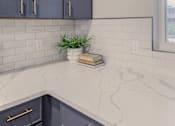 Thumbnail 9 of 27 - A kitchen with dark blue cabinets and a marble countertop.
