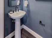 Thumbnail 10 of 27 - A bathroom with a sink and a mirror.