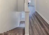Thumbnail 11 of 27 - A hallway with wood flooring and white walls.