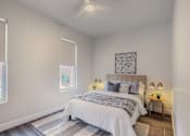 Thumbnail 12 of 27 - A bedroom with a large bed and a ceiling fan.