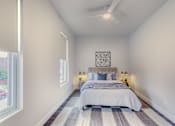 Thumbnail 13 of 27 - A bedroom with a bed, pillows, and a ceiling fan.