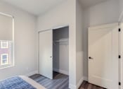 Thumbnail 18 of 27 - A bedroom with a bed and a closet.