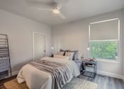 Thumbnail 21 of 27 - A bedroom with a large bed and a window with blinds.