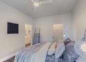 Thumbnail 22 of 27 - A bedroom with a bed and a ceiling fan.
