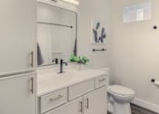 Thumbnail 23 of 27 - A white bathroom with a toilet, sink, and mirror.