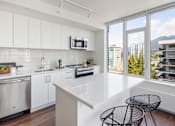 Thumbnail 13 of 13 - A modern kitchen with white cabinets and a large island.