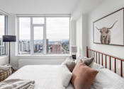 Thumbnail 7 of 13 - A bedroom with a large bed and a painting of a bull on the wall.
