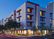 Thumbnail 10 of 15 - an apartment building on a city street at dusk