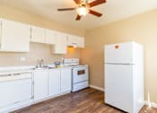 Thumbnail 2 of 22 - a kitchen with white appliances and a ceiling fan