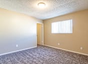 Thumbnail 6 of 22 - an empty living room with a door to a hallway and a window