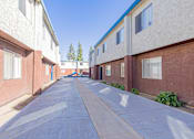 Thumbnail 10 of 22 - an empty alley between two buildings with a blue sky