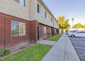 Thumbnail 11 of 22 - a side view of a building with a sidewalk and cars parked