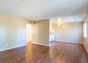 Thumbnail 3 of 22 - an empty living room with wood flooring and a kitchen