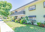Thumbnail 2 of 25 - a yellow house with a garden in front of it