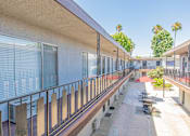 Thumbnail 5 of 25 - a long balcony with tables and chairs at a building with windows