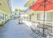 Thumbnail 3 of 25 - a patio with a table and chairs and an umbrella