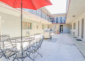 Thumbnail 4 of 25 - a patio with a table and chairs and a red umbrella