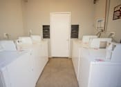 Thumbnail 15 of 25 - a row of washing machines in a room with a door