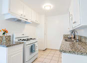 Thumbnail 7 of 25 - a kitchen with white appliances and granite counter tops