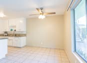 Thumbnail 8 of 25 - an empty kitchen with a ceiling fan and a window