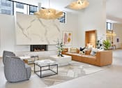 Thumbnail 26 of 107 - A modern living room with a fireplace and a grey armchair.