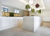 Thumbnail 33 of 107 - A white reception desk with a white wall behind it.