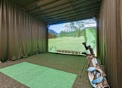 Thumbnail 36 of 107 - A golf simulator room with a screen showing a golf course.