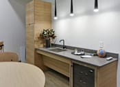 Thumbnail 38 of 107 - A modern kitchen with a wooden island and pendant lights.