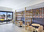 Thumbnail 43 of 107 - A room with a table and chairs and a wall with a pattern on it.