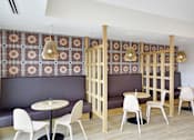 Thumbnail 42 of 107 - A restaurant with a patterned wallpaper and wooden partition.