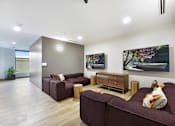 Thumbnail 41 of 107 - A living room with a brown couch and a painting on the wall.