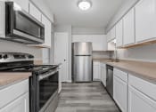 Thumbnail 1 of 13 - an empty kitchen with white cabinets and stainless steel appliances
