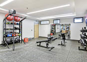 Thumbnail 22 of 107 - A gym with a variety of equipment including weights and benches.