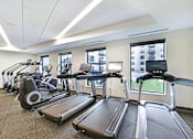 Thumbnail 20 of 107 - A gym with treadmills and elliptical machines.
