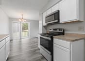 Thumbnail 2 of 13 - the kitchen of our studio apartment atrium with white cabinets and black appliances