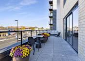 Thumbnail 15 of 107 - A balcony with a table and chairs overlooking a street.