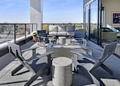 Thumbnail 14 of 107 - A modern outdoor seating area with a table and chairs.