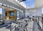 Thumbnail 13 of 107 - A modern balcony with grey furniture and a glass door leading to a living room.
