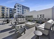 Thumbnail 11 of 107 - A modern outdoor seating area with concrete furniture and a white building in the background.