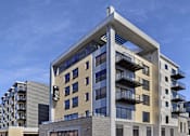 Thumbnail 5 of 107 - A modern building with a glass facade and balconies.