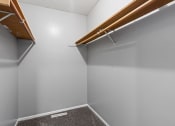 Thumbnail 10 of 13 - a walk in closet in a home with white walls and wood trim