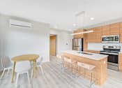 Thumbnail 93 of 107 - A modern kitchen with a wooden table and white chairs.