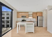Thumbnail 80 of 107 - A modern kitchen with a white table and a refrigerator.