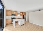 Thumbnail 76 of 107 - A modern kitchen with wooden accents and white appliances.